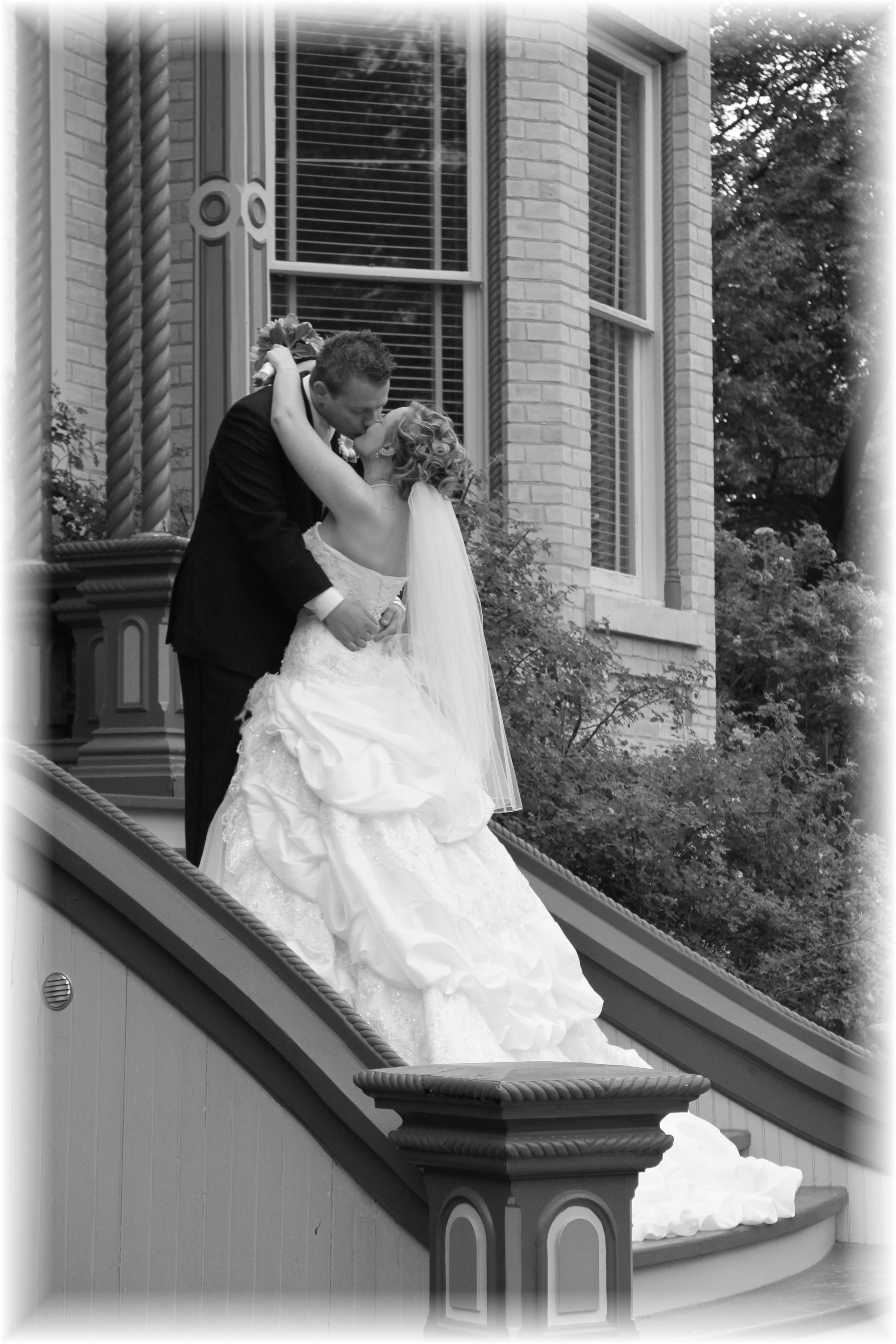 Newly-wed couple kissing on front steps