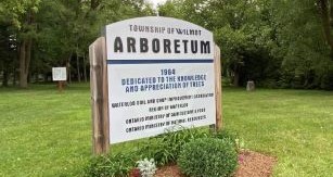 Arboretum sign with green grass and trees