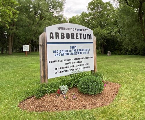 Arboretum Sign with green grass and large trees